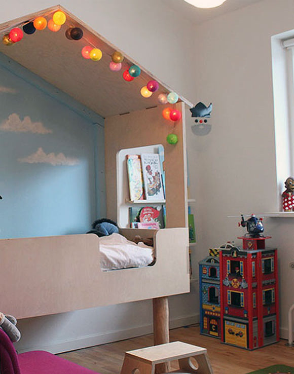 Loft bed with legs made using trees from garden, giving it a forest hut feel