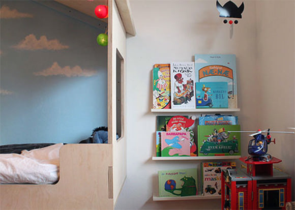 Loft bed with legs made using trees from garden, giving it a forest hut feel